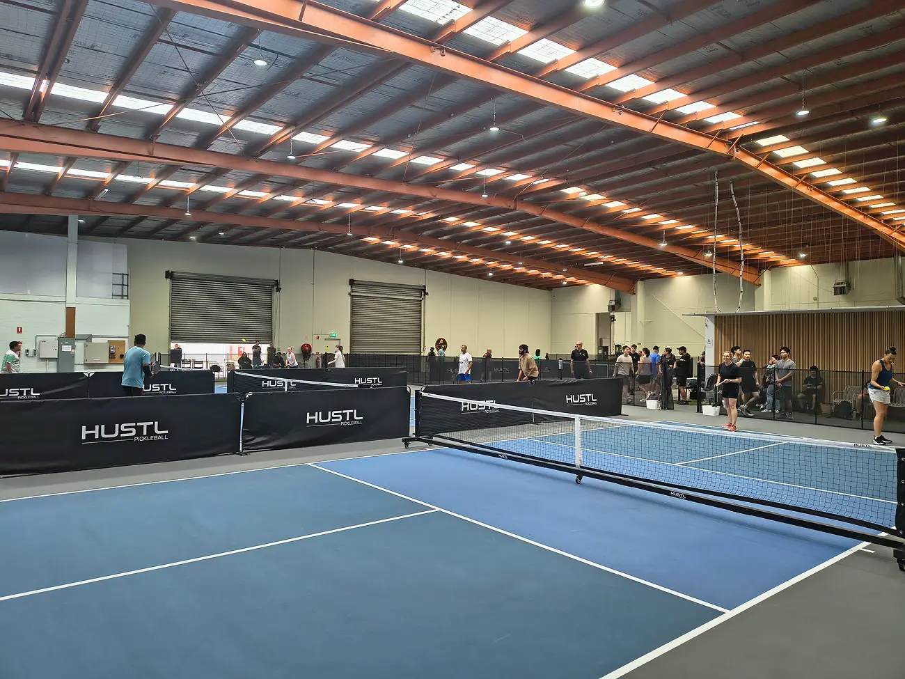 Wide view of multiple courts in use during a first pickleball tournament at Pickleplay Dingley